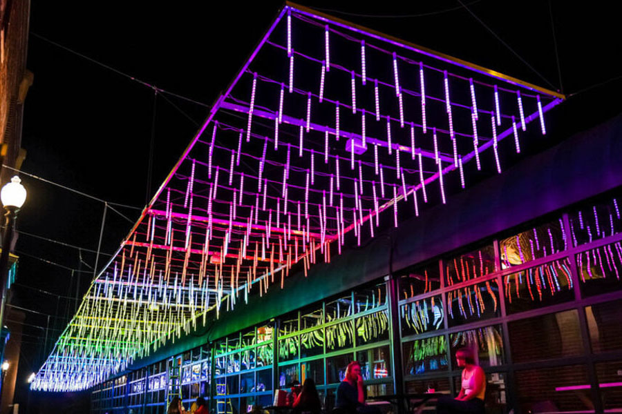 Rainbow light installation hanging between buildings in Georgetown