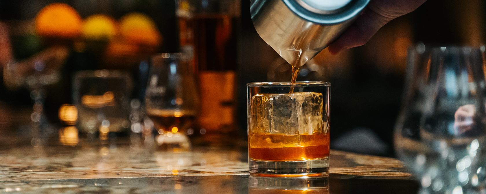 Camarero sirviendo whisky en un vaso