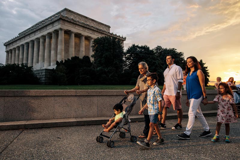 Família caminhando no National Mall em frente ao Lincoln Memorial durante uma noite de verão em Washington, DC