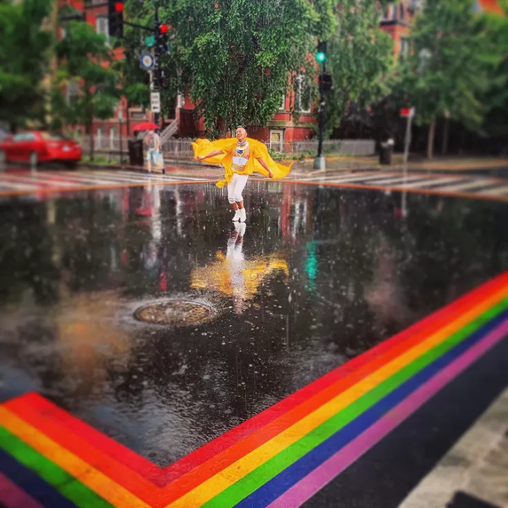 Standing in the rain on a rainbow street