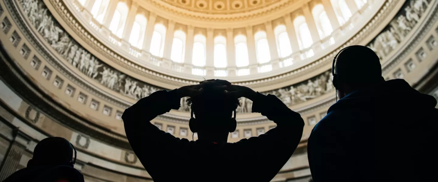 Students silhouetted looking up at the US Capitol Dome