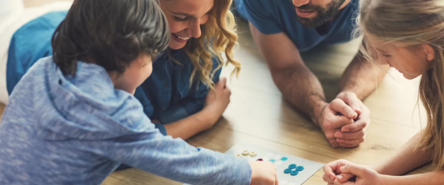 Family on floor playing board game