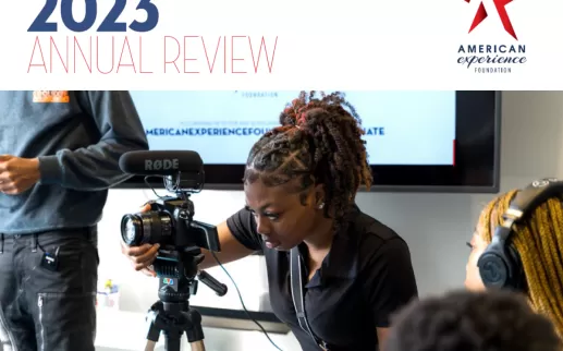 Annual Review 2023 - a young Black woman sits behind a camera filming
