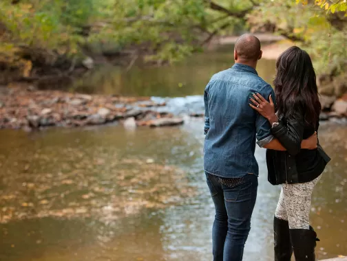 A couple watches the stream in Rock Creek Park.