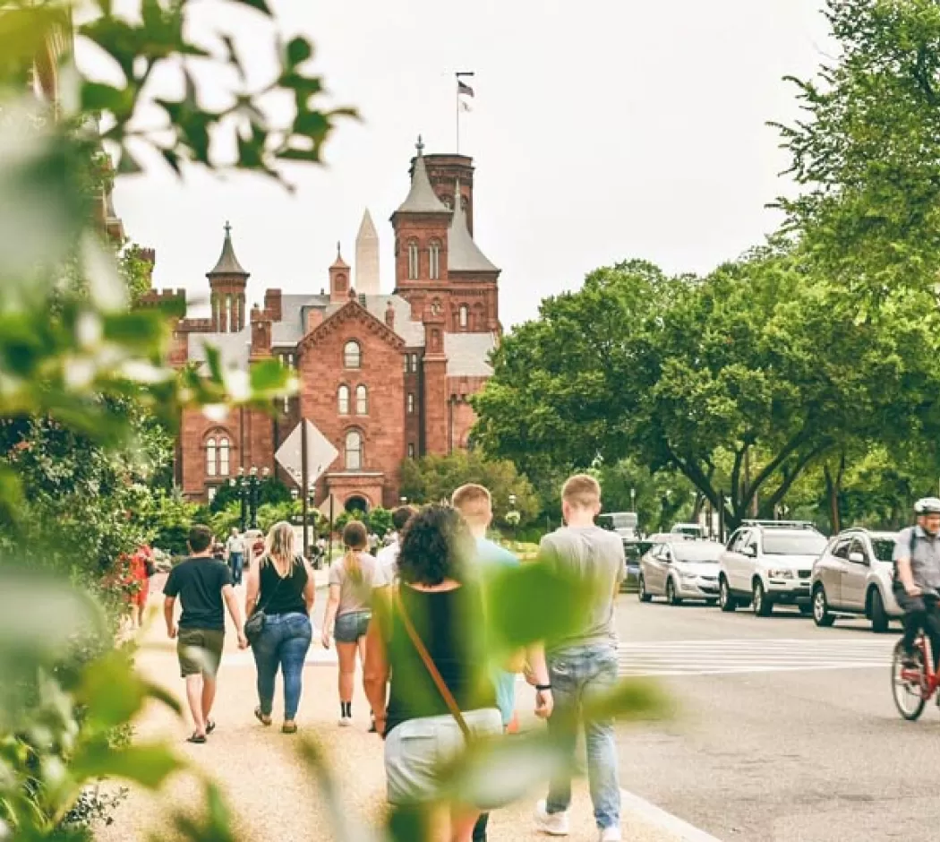 Visitors walking by the Smithsonian Castle on the National Mall in Washington, DC